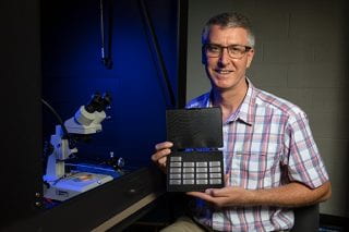 Paul Thibado, professor of physics, with sample energy-harvesting chips under development.